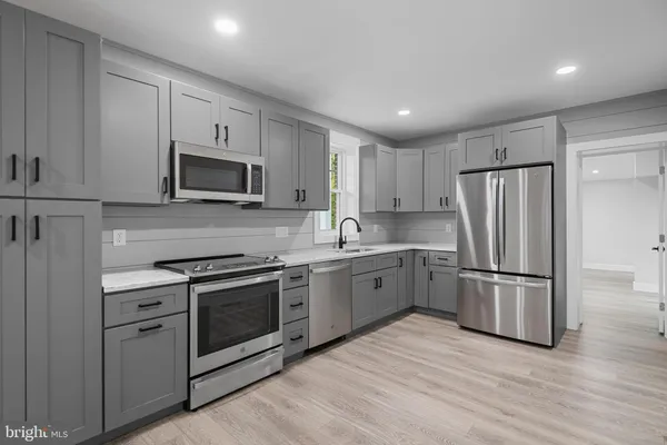 a kitchen with granite countertop a refrigerator stove and microwave
