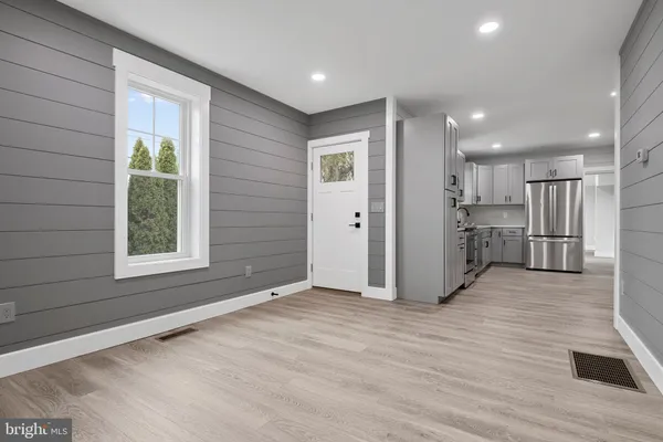 a view of empty room with wooden floor and window