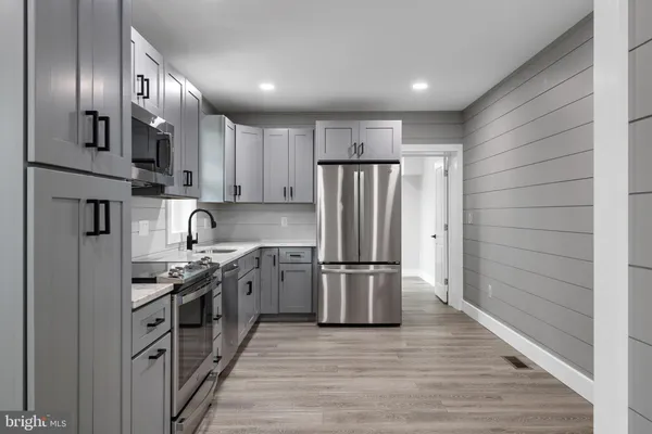 a kitchen with stainless steel appliances granite countertop a refrigerator a stove and a sink