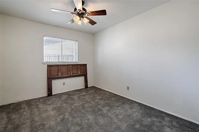 a view of an empty room and chandelier fan