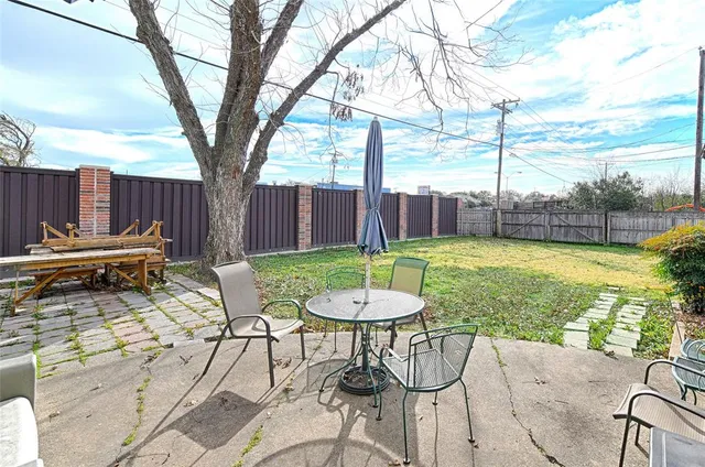 a view of backyard with wooden fence and a barbeque