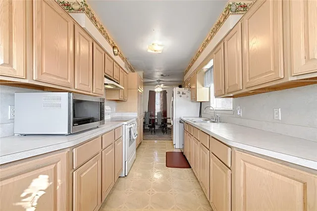 a kitchen with stainless steel appliances granite countertop a sink and dishwasher a stove top oven with white cabinets