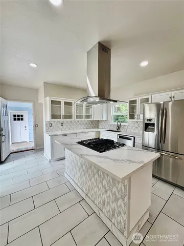 a kitchen with stainless steel appliances granite countertop a stove a sink and a refrigerator