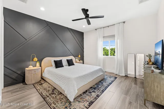 a bedroom with a bed and flat screen tv