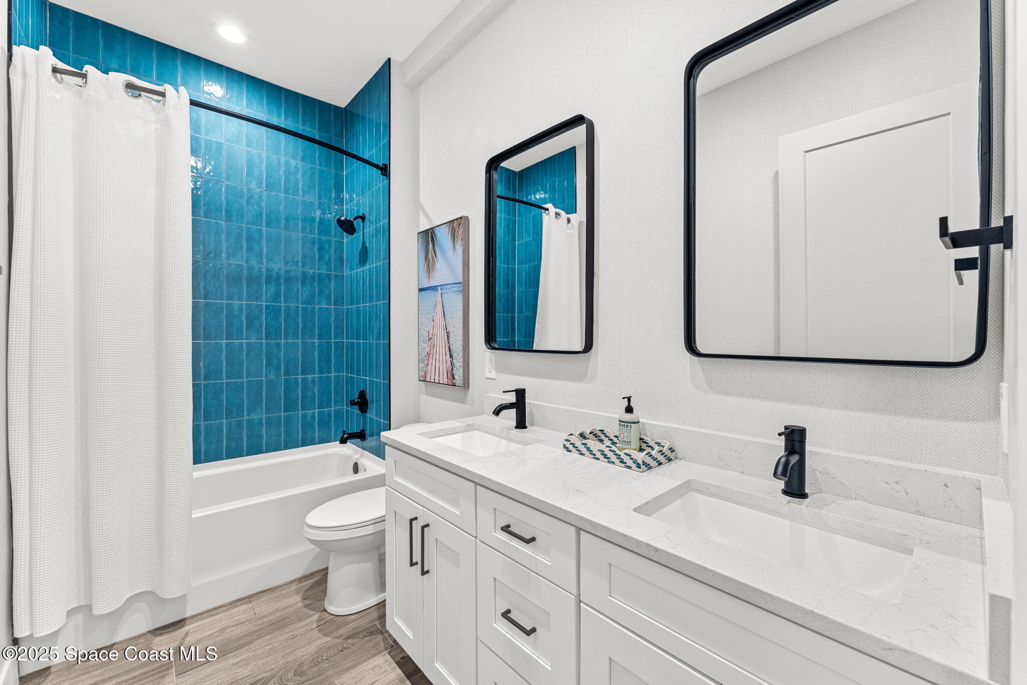 106 4th Avenue Indialantic, FL 32903 - Photo 23 of 37 a bathroom with double vanity sinks a toilet a mirror and shower