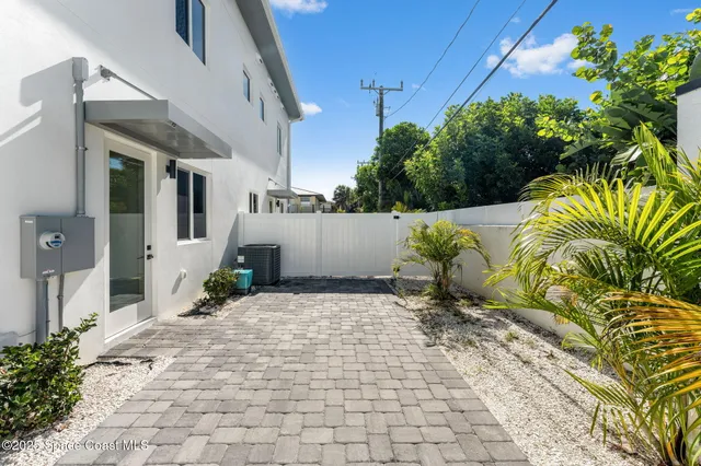 a view of a house with a yard and potted plants