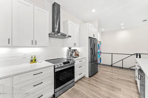 a view of a kitchen with kitchen island a sink stainless steel appliances and a counter top space
