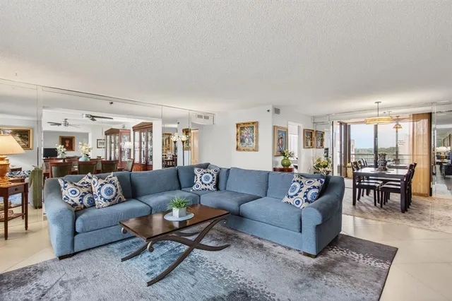 a kitchen with stainless steel appliances a sink a stove a refrigerator cabinets and a dining table