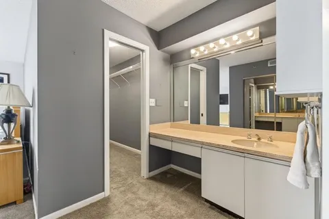 a front view of a building with plants and lake view