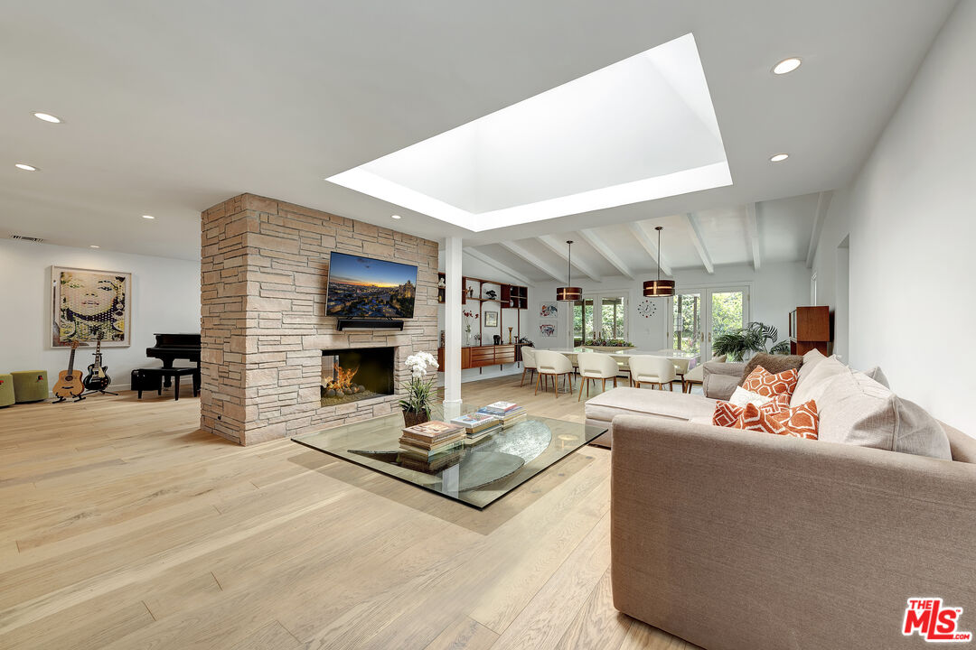 16012 Meadowcrest Road Sherman Oaks, CA 91403 - Photo 12 of 52 a living room with furniture flat screen tv and a fireplace