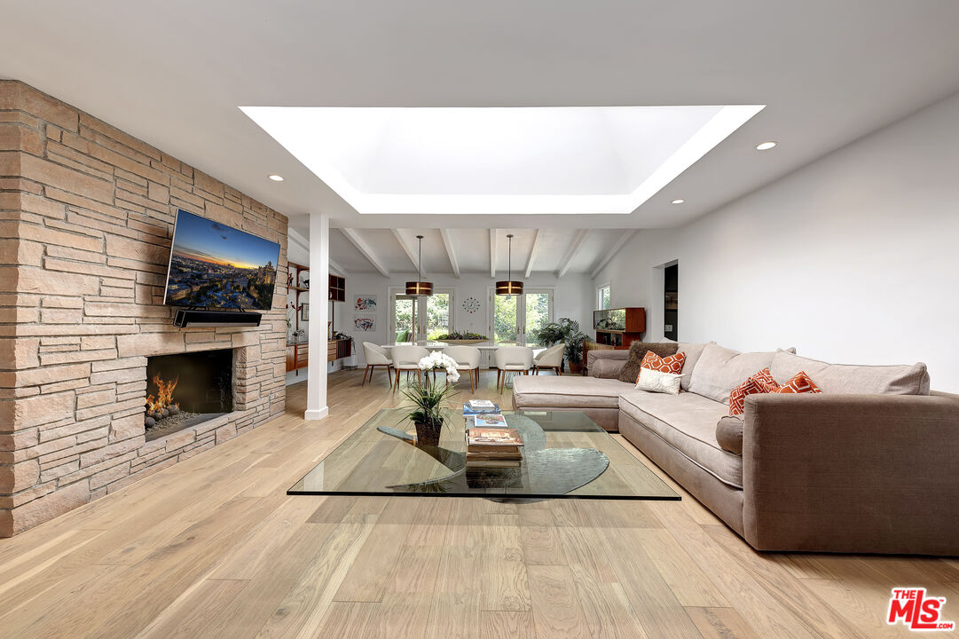 16012 Meadowcrest Road Sherman Oaks, CA 91403 - Photo 13 of 52 a living room with furniture a fireplace and a flat screen tv