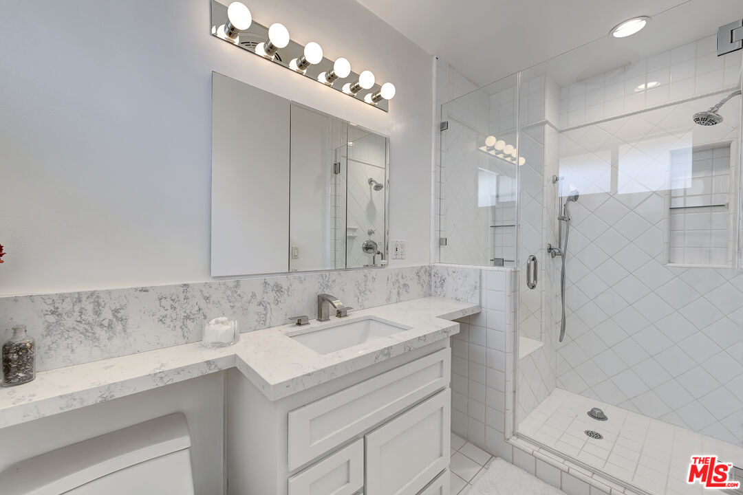 16012 Meadowcrest Road Sherman Oaks, CA 91403 - Photo 29 of 52 a bathroom with a sink double vanity and shower