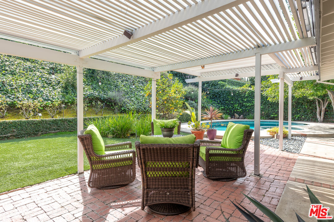 16012 Meadowcrest Road Sherman Oaks, CA 91403 - Photo 36 of 52 a view of a patio with a table chairs and backyard