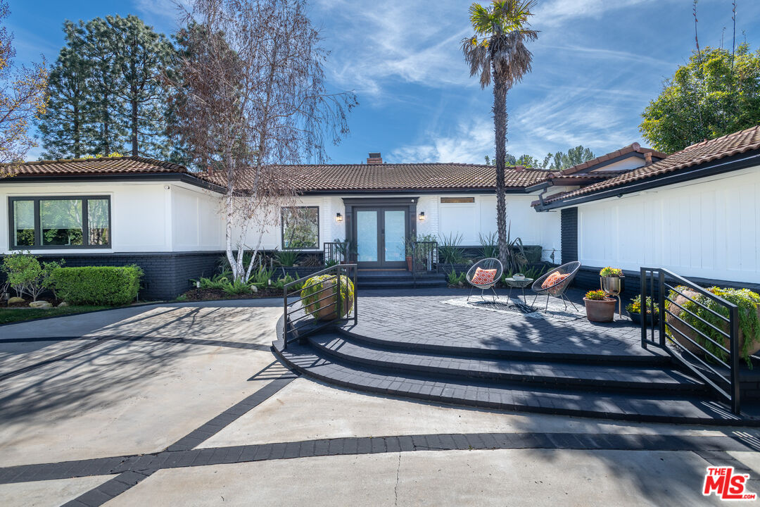 16012 Meadowcrest Road Sherman Oaks, CA 91403 - Photo 9 of 52 a front view of a house with garden