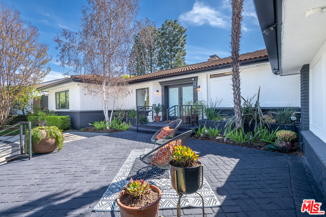 16012 Meadowcrest Road Sherman Oaks, CA 91403 - Photo 10 of 52 a view of a patio with couches table and chairs potted plants and wooden floor