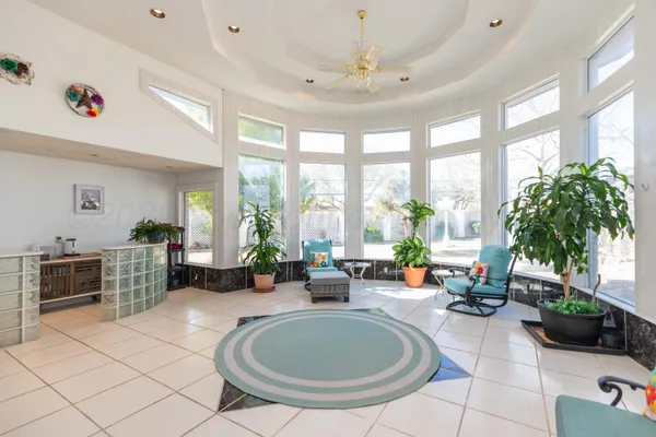 a large living room with stainless steel appliances furniture and a chandelier