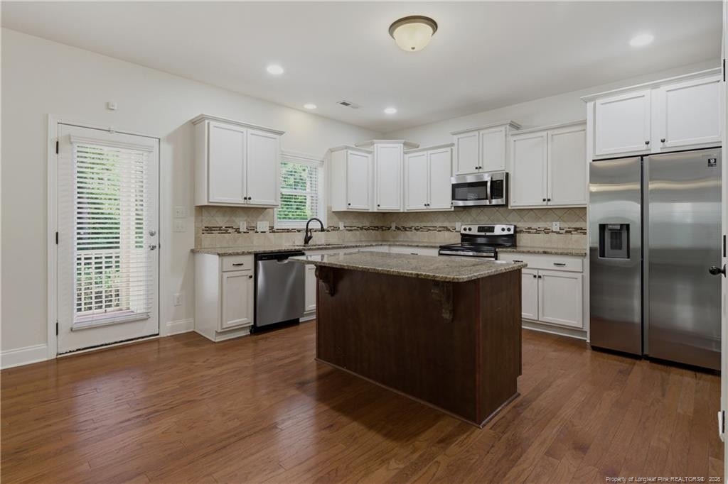 182 Valley Stream Road Spring Lake, NC 28390 - Photo 5 of 33 a kitchen with stainless steel appliances granite countertop a stove a sink dishwasher a refrigerator and a microwave oven with wooden floor