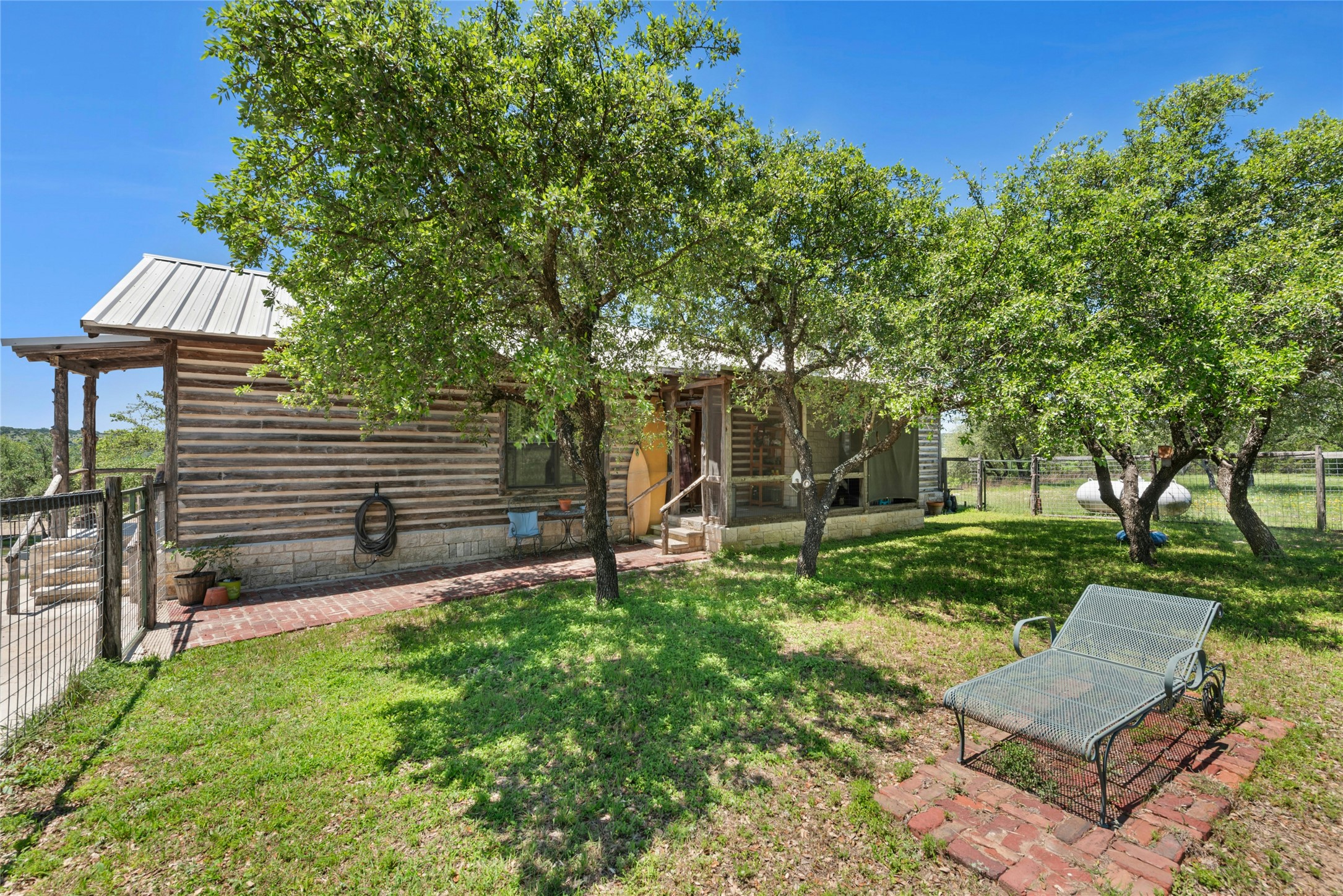 496 Middleton Road Spicewood, TX 78669 - Photo 5 of 40 Log cabin exterior with a metal roof and a covered porch