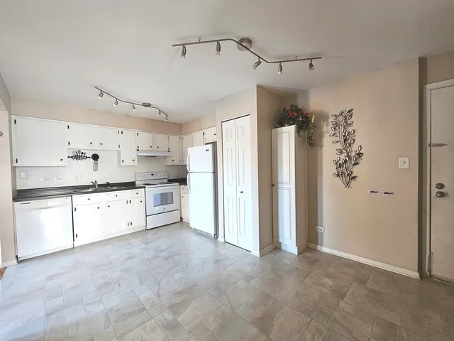 a large white kitchen with cabinets