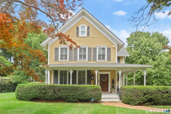 a front view of a house with a yard and trees