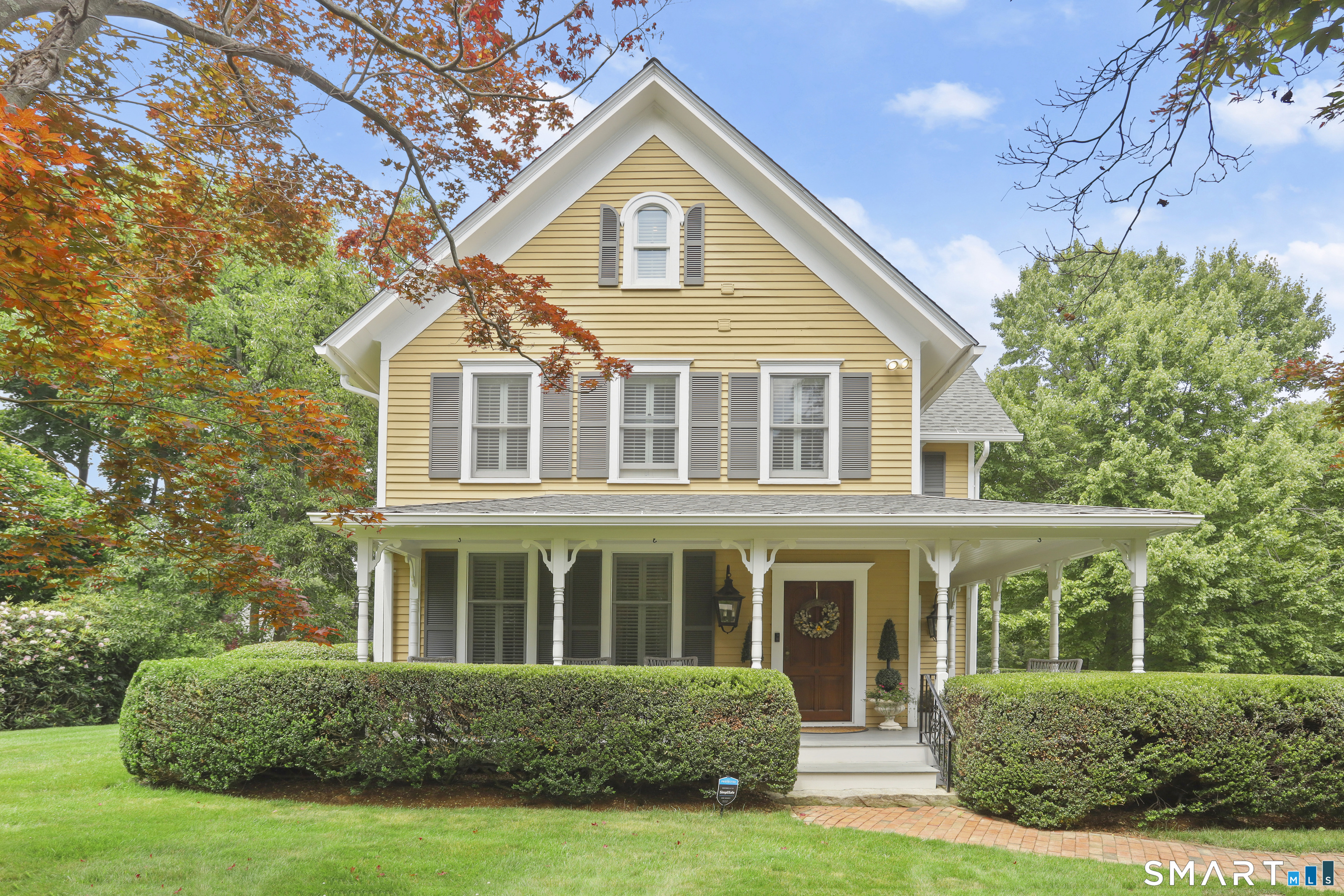 36 Catoonah Street, Unit 18 Ridgefield, CT 06877 - Photo 1 of 40 a front view of a house with a yard and trees