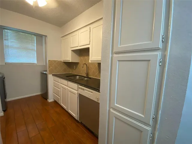 a kitchen with a refrigerator and white cabinets