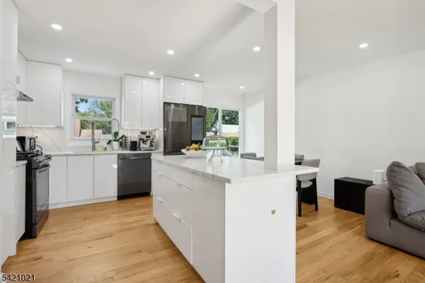 a kitchen with stainless steel appliances kitchen island granite countertop a sink and a refrigerator