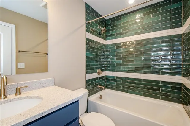 a bathroom with a granite countertop sink mirror and shower
