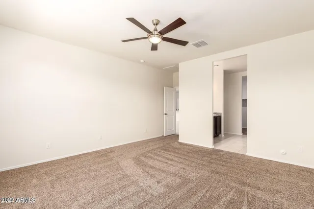 an empty room with closet and ceiling fan