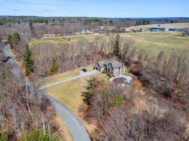 an aerial view of a house with a yard and lake view