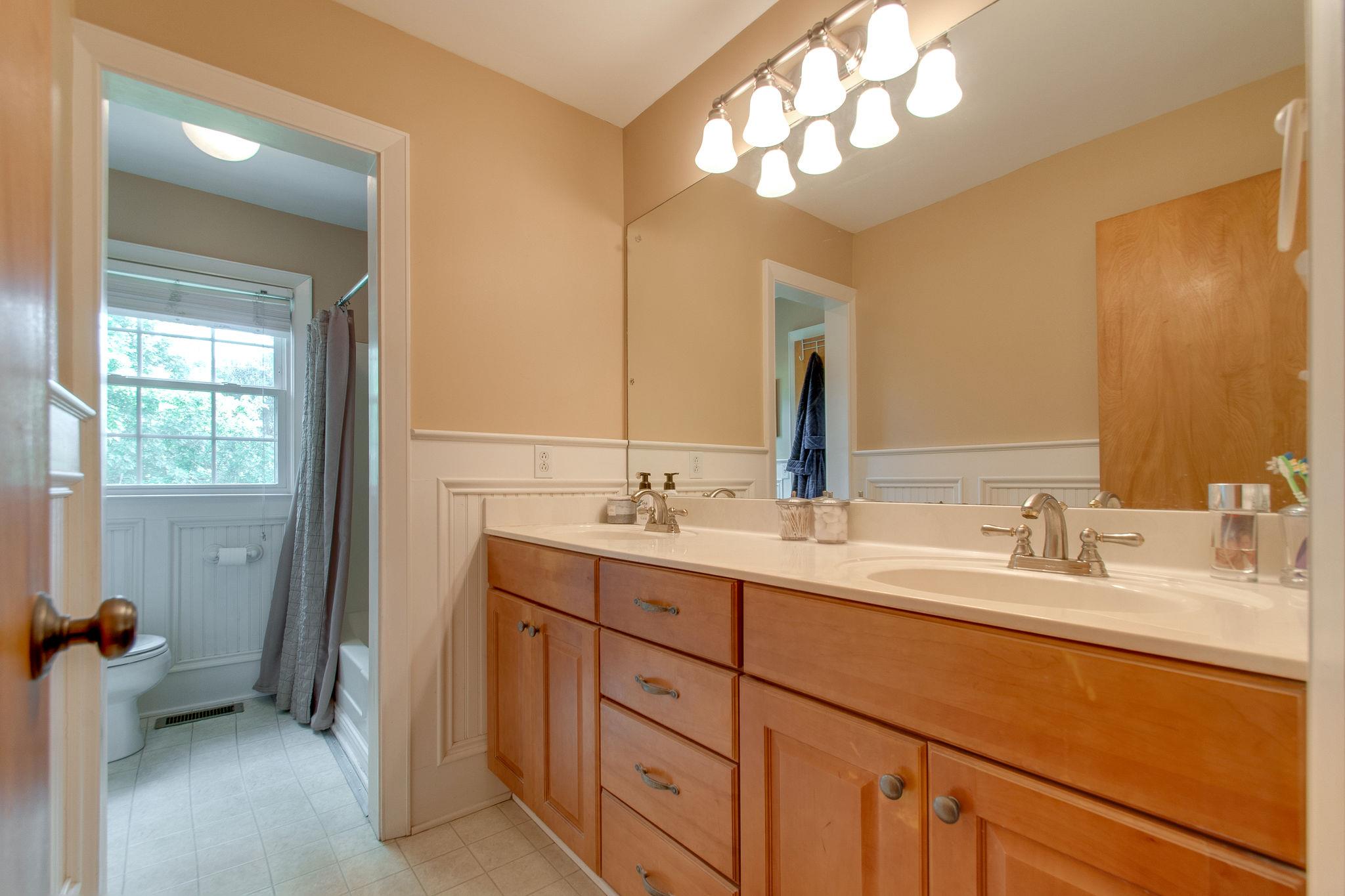9576 Mullens Road Arrington, TN 37014 - Photo 17 of 26 a bathroom with a double vanity sink and a mirror