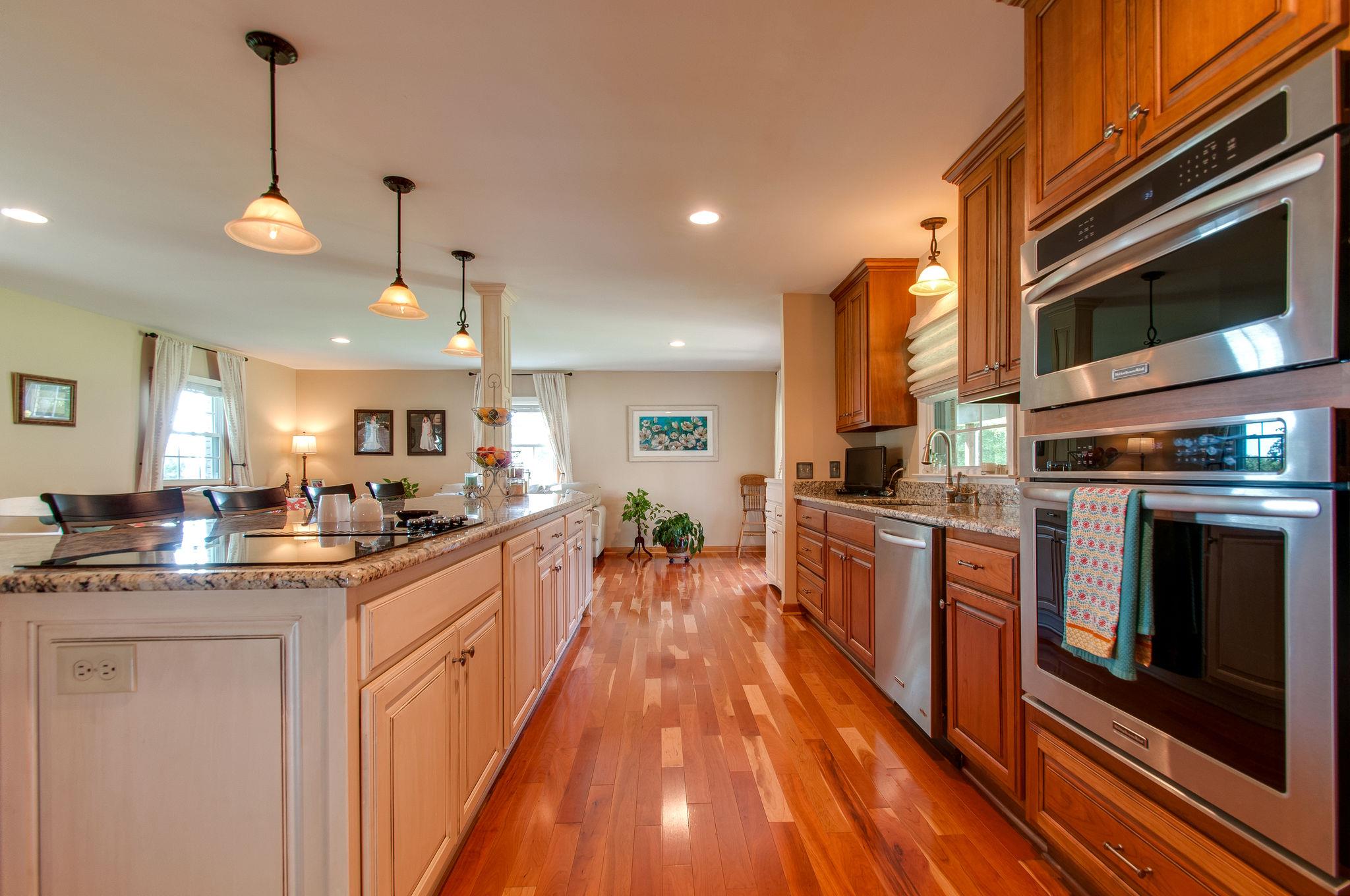 9576 Mullens Road Arrington, TN 37014 - Photo 7 of 26 a large kitchen with stainless steel appliances granite countertop a stove a sink dishwasher and a microwave oven with large wooden cabinets