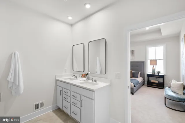 a spacious bathroom with double vanity and mirrors
