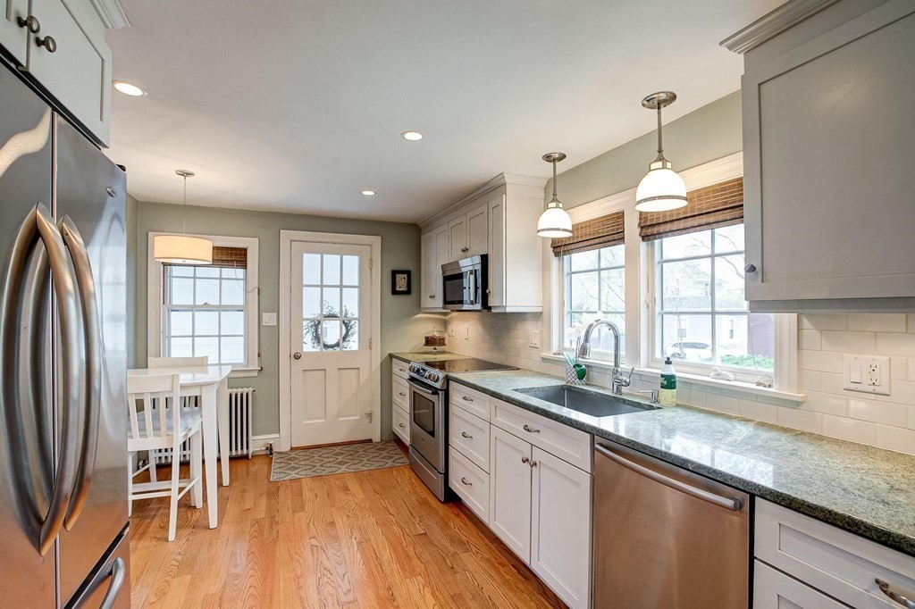 4 Pine Hill Circle Wakefield, MA 01880 - Photo 10 of 41 a kitchen with granite countertop a refrigerator a sink dishwasher a dining table and chairs with wooden floor
