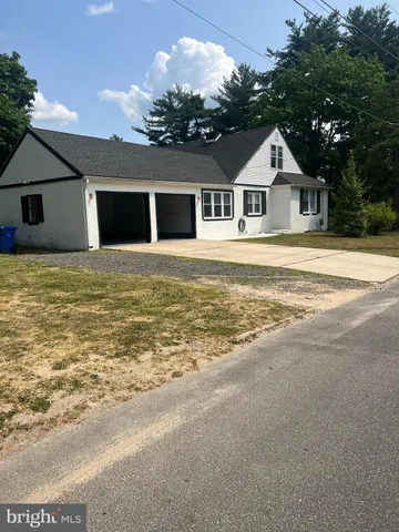 a front view of house with yard and trees in the background