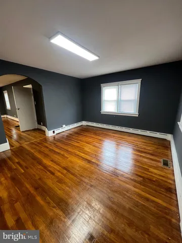 a living room with chairs wooden floor and a fireplace