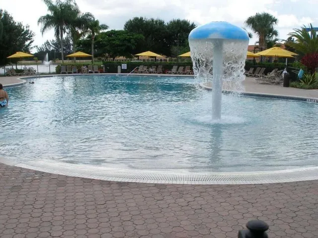 a view of a swimming pool with a patio and plants