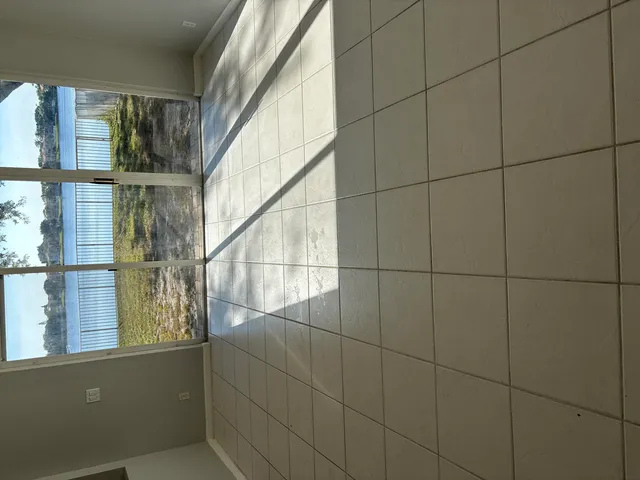 a view of a bathroom with window and brick walls