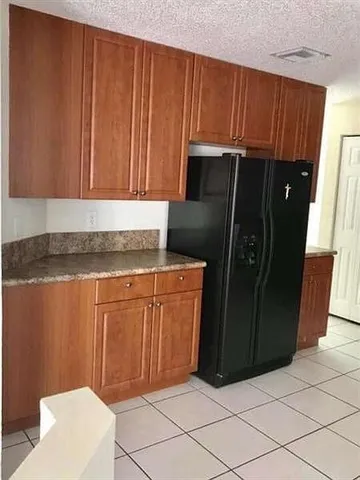 a kitchen with granite countertop cabinets and refrigerator