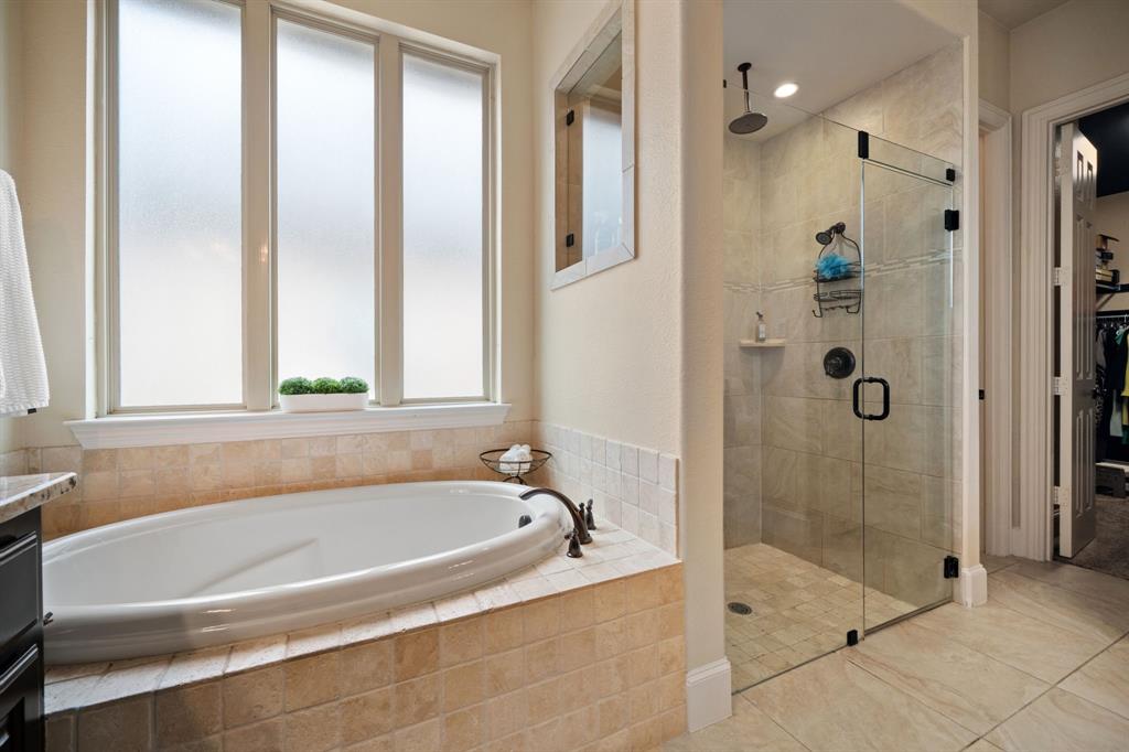 2114 Spicewood Drive Allen, TX 75013 - Photo 19 of 37 a bathroom with a bathtub and shower