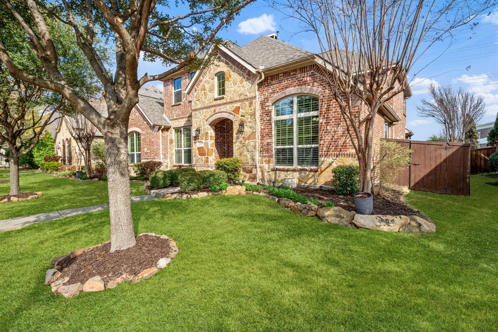2114 Spicewood Drive Allen, TX 75013 - Photo 2 of 37 a front view of a house with a garden and tree