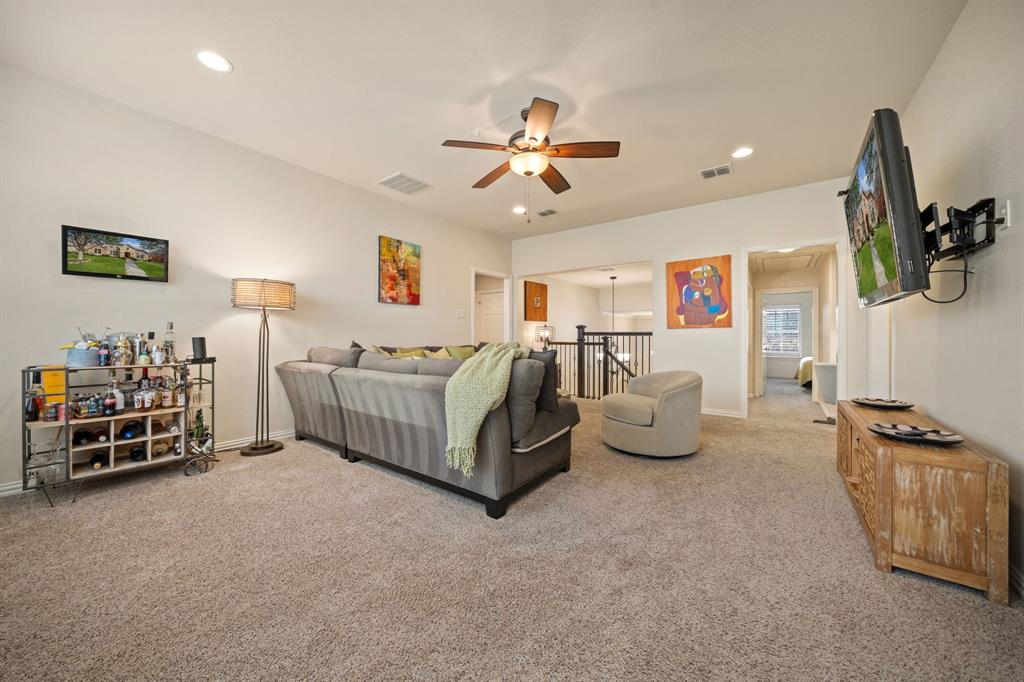 2114 Spicewood Drive Allen, TX 75013 - Photo 22 of 37 a spacious bedroom with a bed a couch and a chandelier