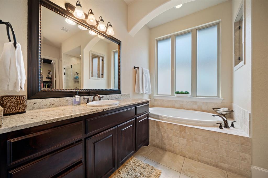 2114 Spicewood Drive Allen, TX 75013 - Photo 26 of 37 a bathroom with a tub sink and mirror