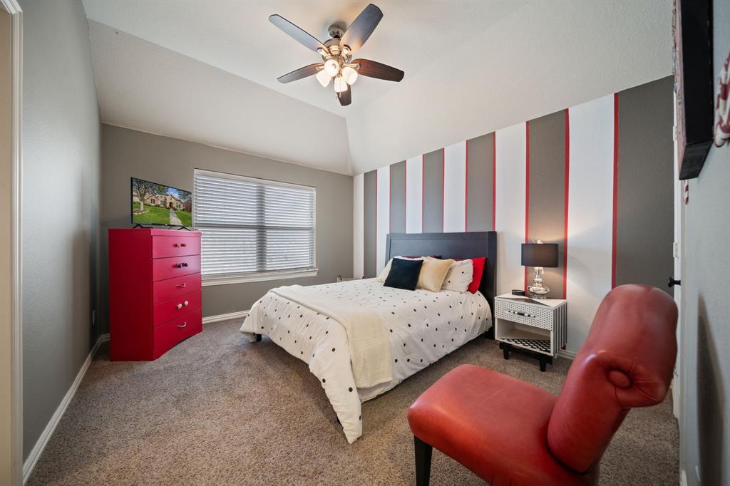 2114 Spicewood Drive Allen, TX 75013 - Photo 30 of 37 a bedroom with a bed and a chandelier