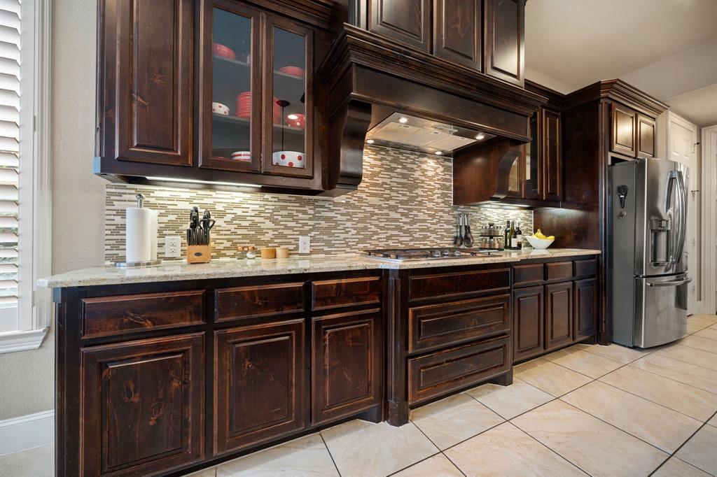 2114 Spicewood Drive Allen, TX 75013 - Photo 10 of 37 a kitchen with stainless steel appliances granite countertop wooden cabinets and a counter top space