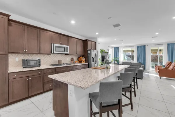 a kitchen with stainless steel appliances granite countertop a refrigerator and a stove top oven