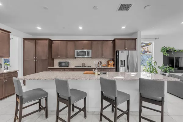 a kitchen with granite countertop kitchen island a sink appliances and a counter top space