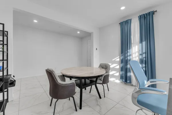 a kitchen with kitchen island a dining table and chairs