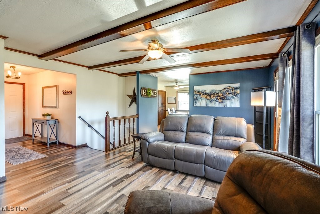 1157 Bass Circle Northwest Canton, OH 44708 - Photo 7 of 31 Living room featuring light wood-type flooring, baseboards, beamed ceiling, and ceiling fan