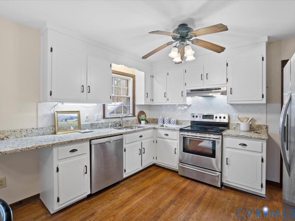 1145 Timber Trace Road Powhatan, VA 23139 - Photo 10 of 32 a kitchen with stainless steel appliances granite countertop a sink a stove a refrigerator and island with wooden floor